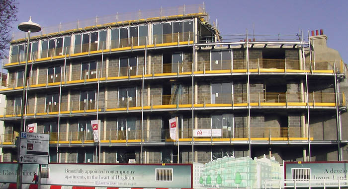 A wide angle photo which shows what the building looks like in reality - half finished - the drawing is included at the base of the building