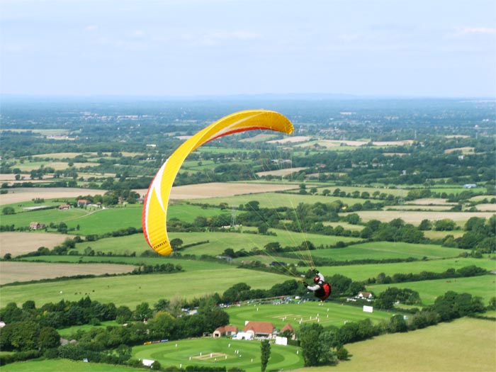 Photo of a hang glider above a cricket match