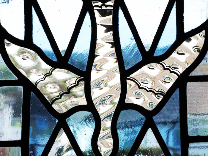 Stained glass window of a dove descending