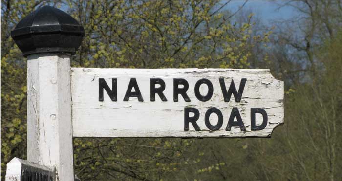 An old road sign reads "Narrow road"