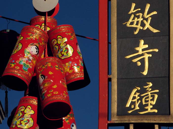 A Chinese sign with gold lettering glistens in the sun.