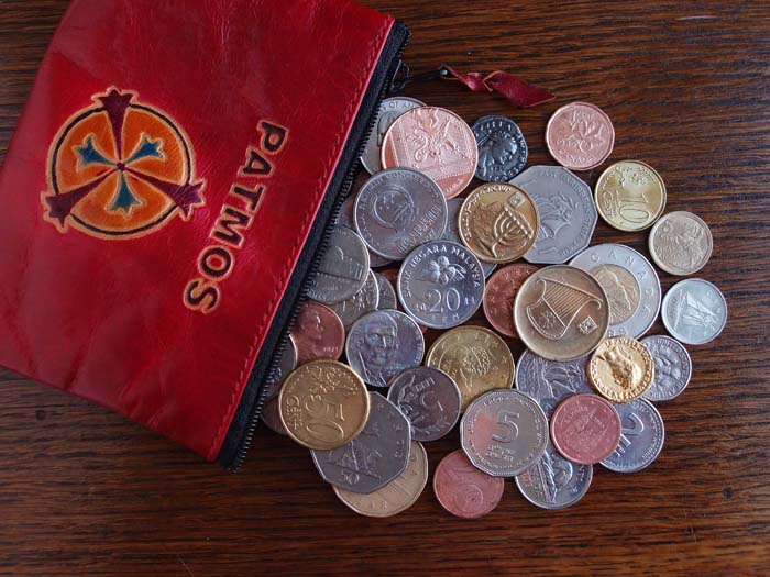 A red purse enscribed Patmos has spilled coins of the nations onto a table